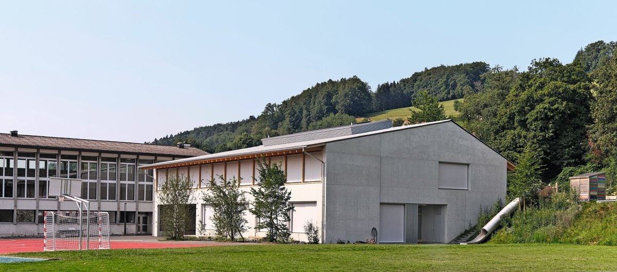 Der Neubau und das bestehende Mehrzweckgebäude werden um einen Pausenhof und Sportplatz ergänzt.