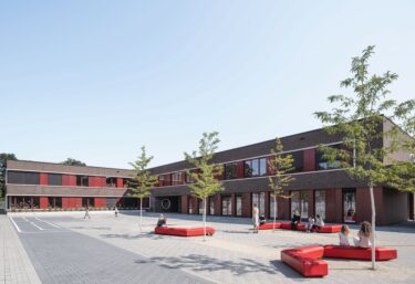 Zum weitläufigen Schulcampus hin umklammert der Grundschulneubau der Henri-Dunant-Schule den neu gefassten Pausenhof L-förmig.