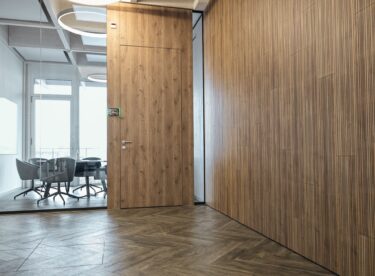 Ästhetisch und akustisch wirksam für ein gesteigertes Wohlbefinden in Innenräumen: «Swissclic Panel-A+». Damit sich die Innenräume durch weite Holzflächen auszeichnen, wurde für Wände und Türen dasselbe Dekor, «D5291 Creative – Riviera Oak», verwendet. Fotos: Swiss Krono AG