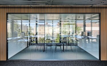 Die Büroflächen sind als Open Space konzipiert und mittig durch eine Begegnungszone mit Sitzungszimmer und Besprechungsmöglichkeiten mit Glas und offenen Durchgängen unterteilt.