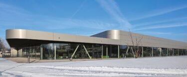 Das Gebäude gliedert sich in zwei Volumen, die sich in ihrer Nutzung und in der Höhe unterscheiden