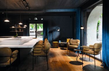 Statt an einzelnen Tischen sitzen die Besuchenden an einem Tresen, der sich wie ein Hufeisen um die offene Küche zieht.