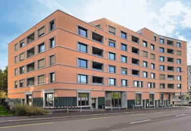 Betonelemente gliedern die Fassade und übernehmen mit Gurtgesimsen und Fensterleibungen die horizontale und vertikale Strukturierung.